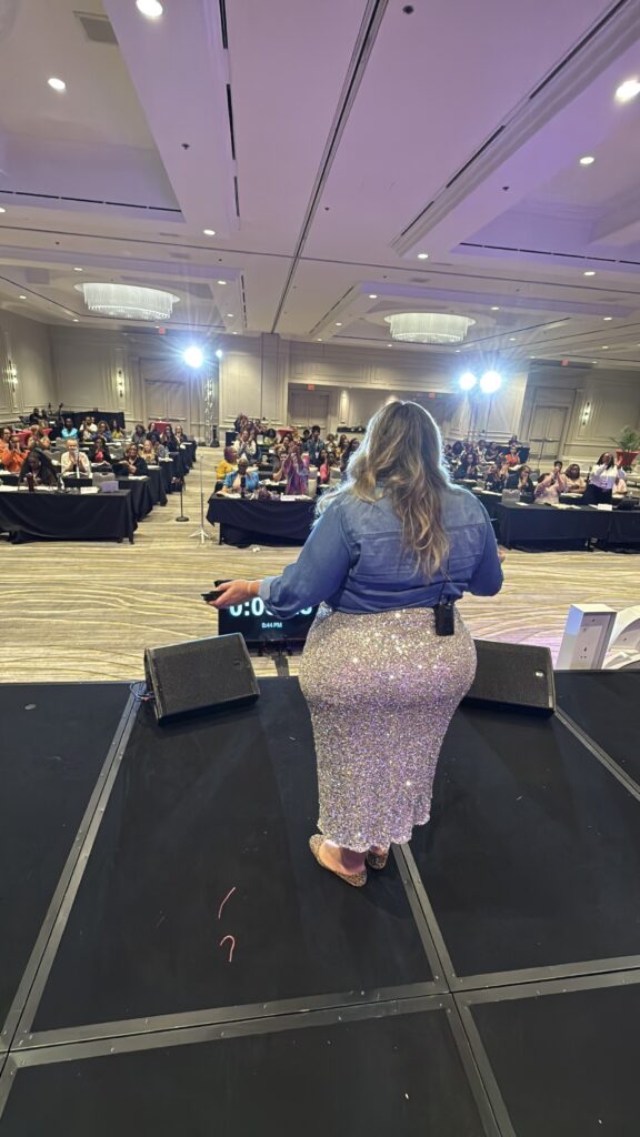 alessia standing on stage speaking at marketing school live